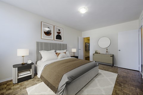 A bedroom with a large bed and a nightstand with a lamp.